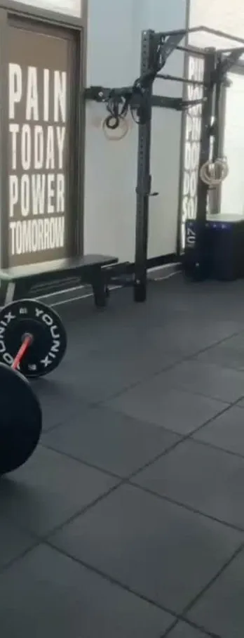 Slogan wall, rig with gymnastic rings and bumper plates on the gym floor